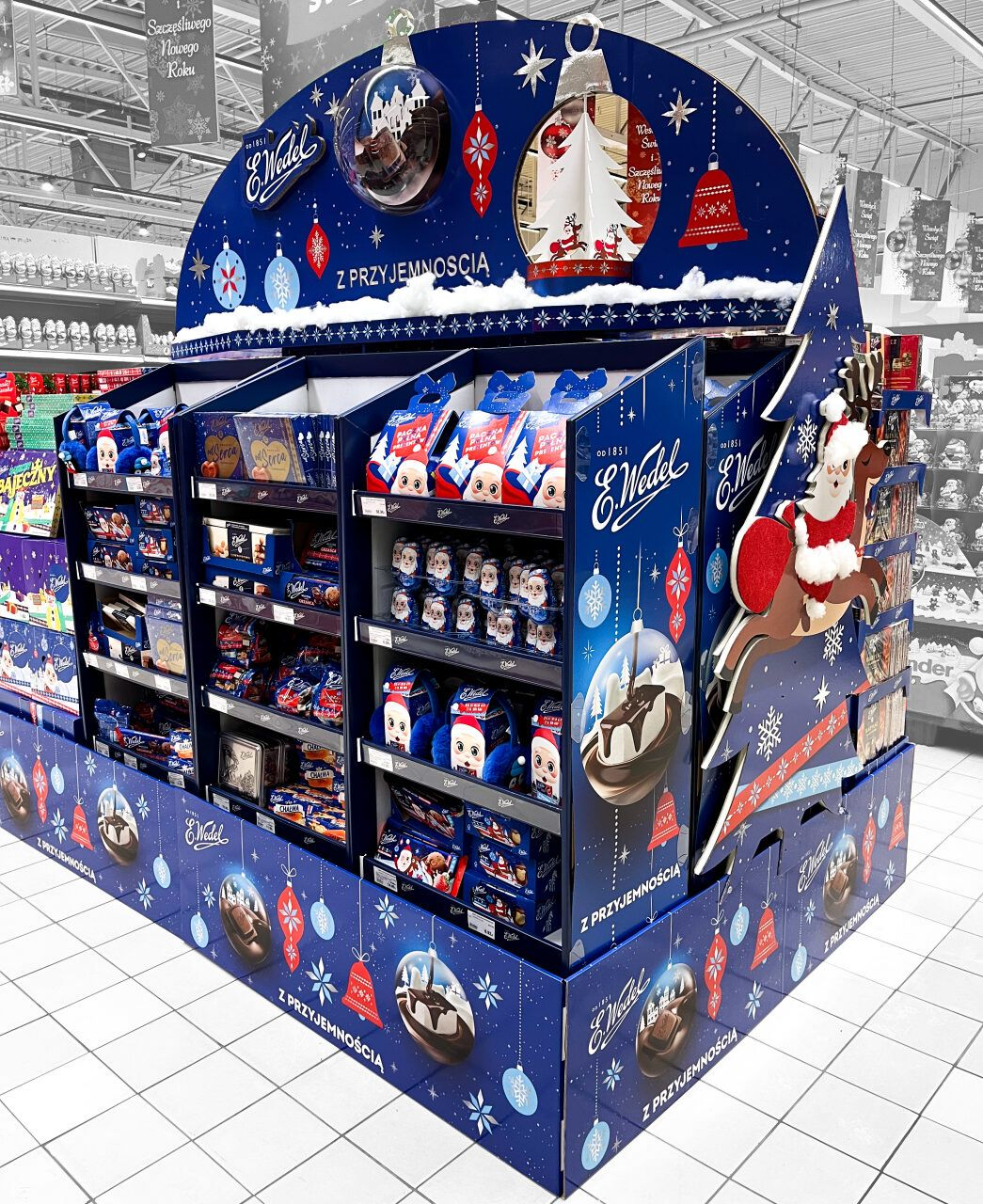 A collection of custom cardboard displays showcasing various products in a retail store.