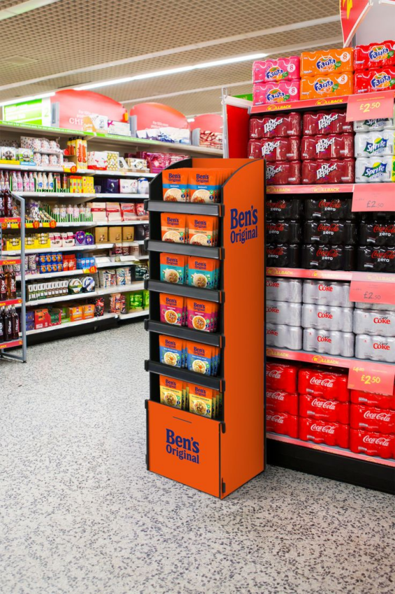 A well-organized store aisle with clear signage and themed floor displays guiding customers.