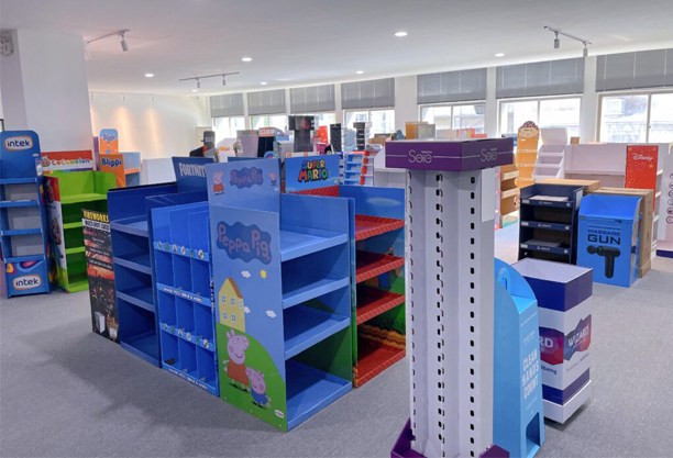 A variety of colorful cardboard POP displays in a retail setting
