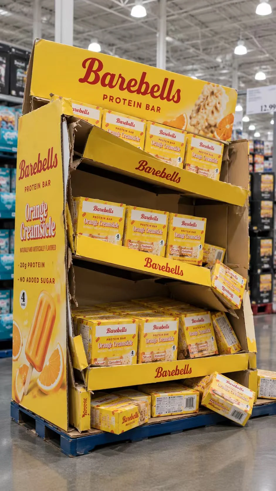 Protein bar cardboard display with sloping shelves and products shifting forward